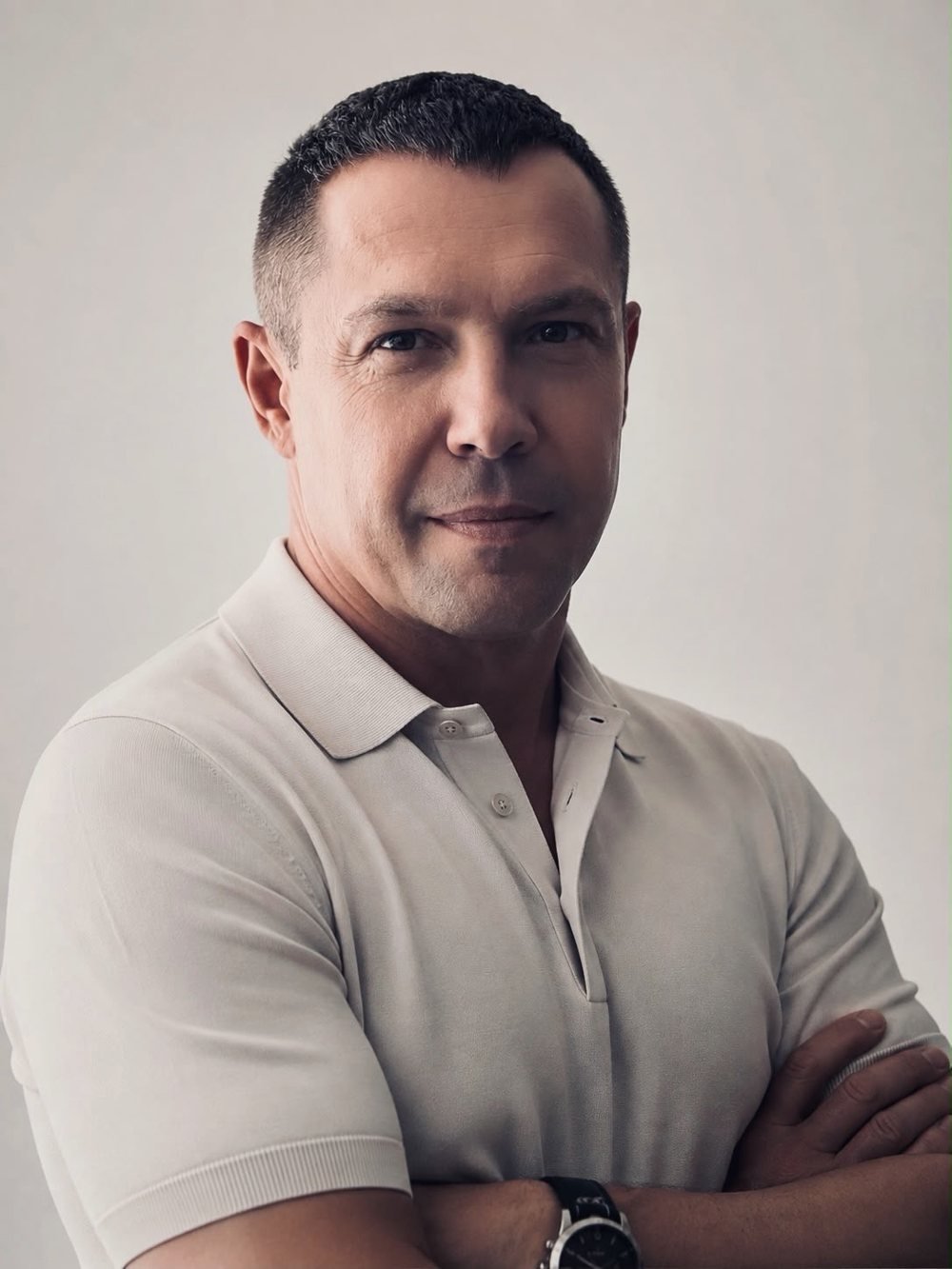 Mykhailo Andrukhovych, AI automation specialist, arms crossed in a light polo shirt
